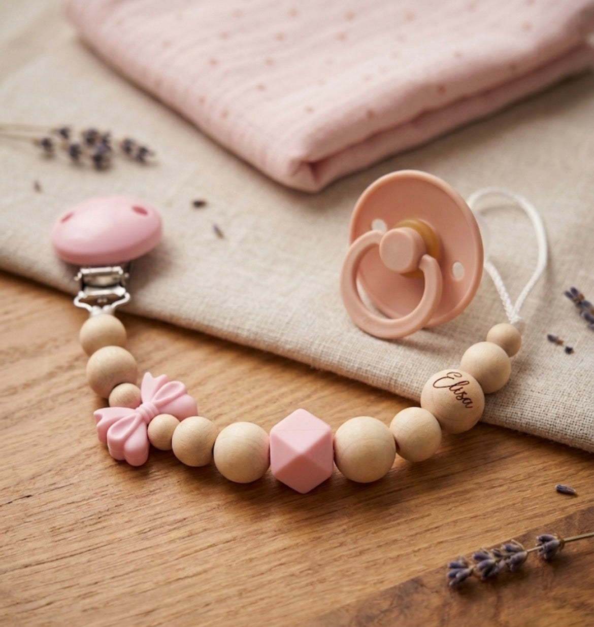 Personalisierte Schnullerkette mit Namen, Gravur, rosa Schleife, Holzperlen und Silikonperlen – individuelles Babygeschenk zur Geburt oder Taufe.